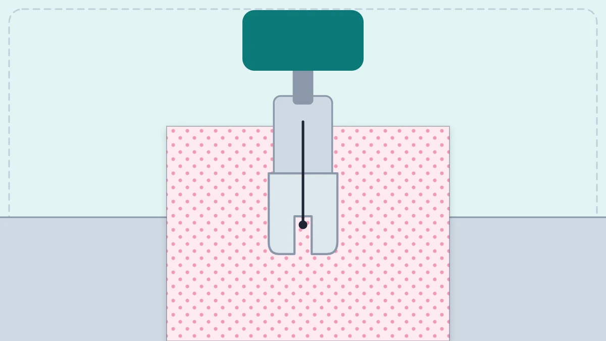 Fabric under a presser foot with a straight line of stitching behind the needle